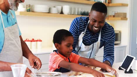 Boy-preparing-cookie-dough-with-his-father-and-grandfather