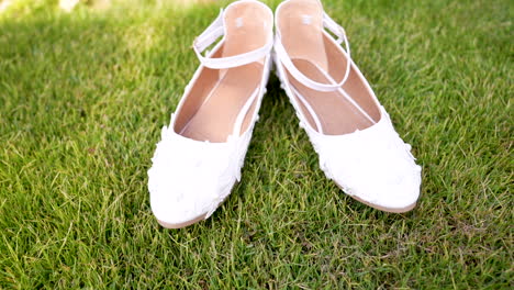 a pair of white shoes sitting on top of a green field