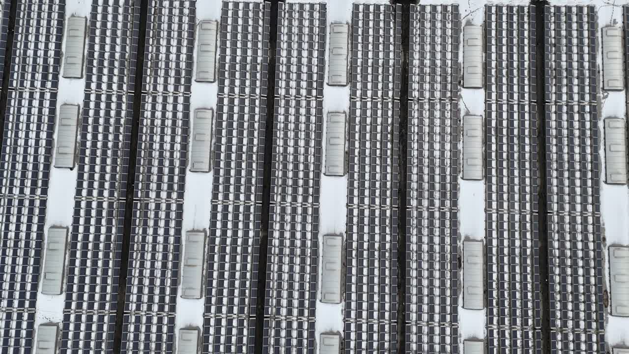 Several Solar panel Units on roof of building during cloudy day. Aerial top down flyover shot. Units installed on rooftop of american company warehouse. Panels farm on house of industrial area of USA.