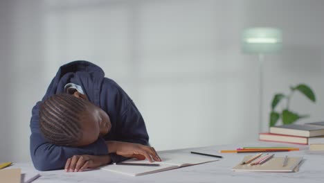 boy on asd spectrum at table at home struggling with concentrating on writing in school book 2