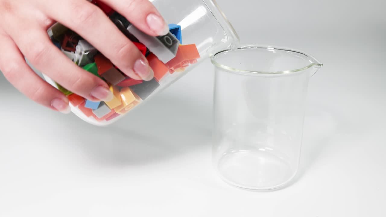 manos moviendo bloques coloridos de un frasco a otro