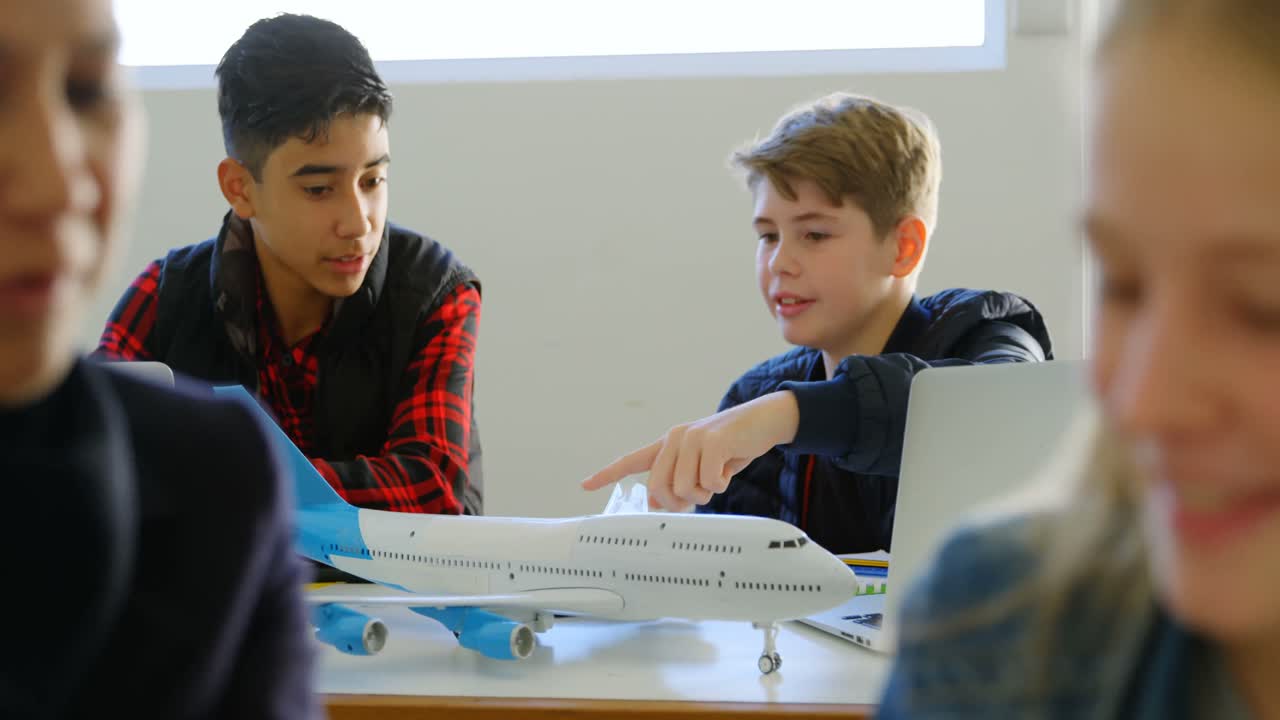 chicos discutiendo sobre el modelo de avión en el instituto de entrenamiento 4k