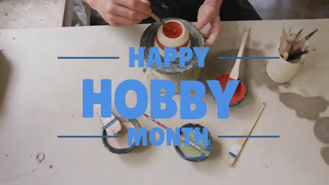 animation of happy hobby month text over caucasian man painting pottery