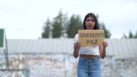 queremos un signo de paz en español sostenido por una joven de américa latina.