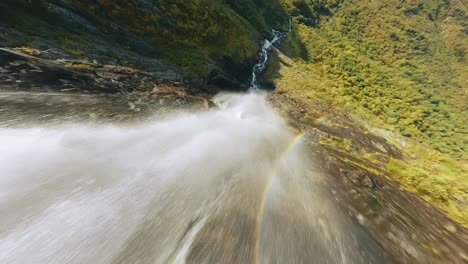 fpv drone diving down a waterfall with incredible view at the end