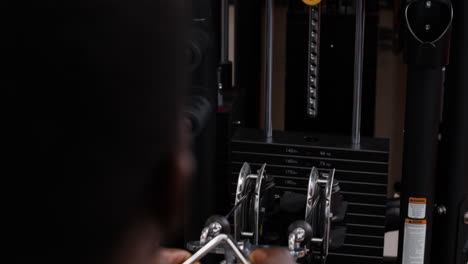 hombre trabajando en una máquina de cable en el gimnasio