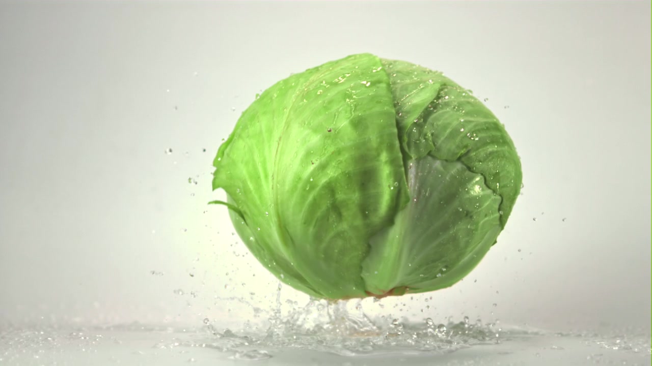Fresh Green Cabbage Dropping and Splashing Water in Slow Motion