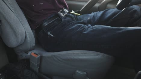 a young driver fastens his seatbelt