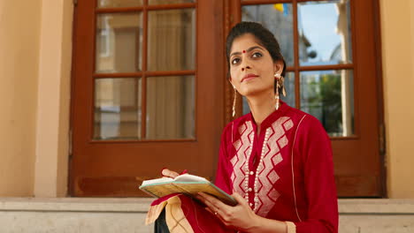 portrait of a beautiful indian woman writing something on her notebook