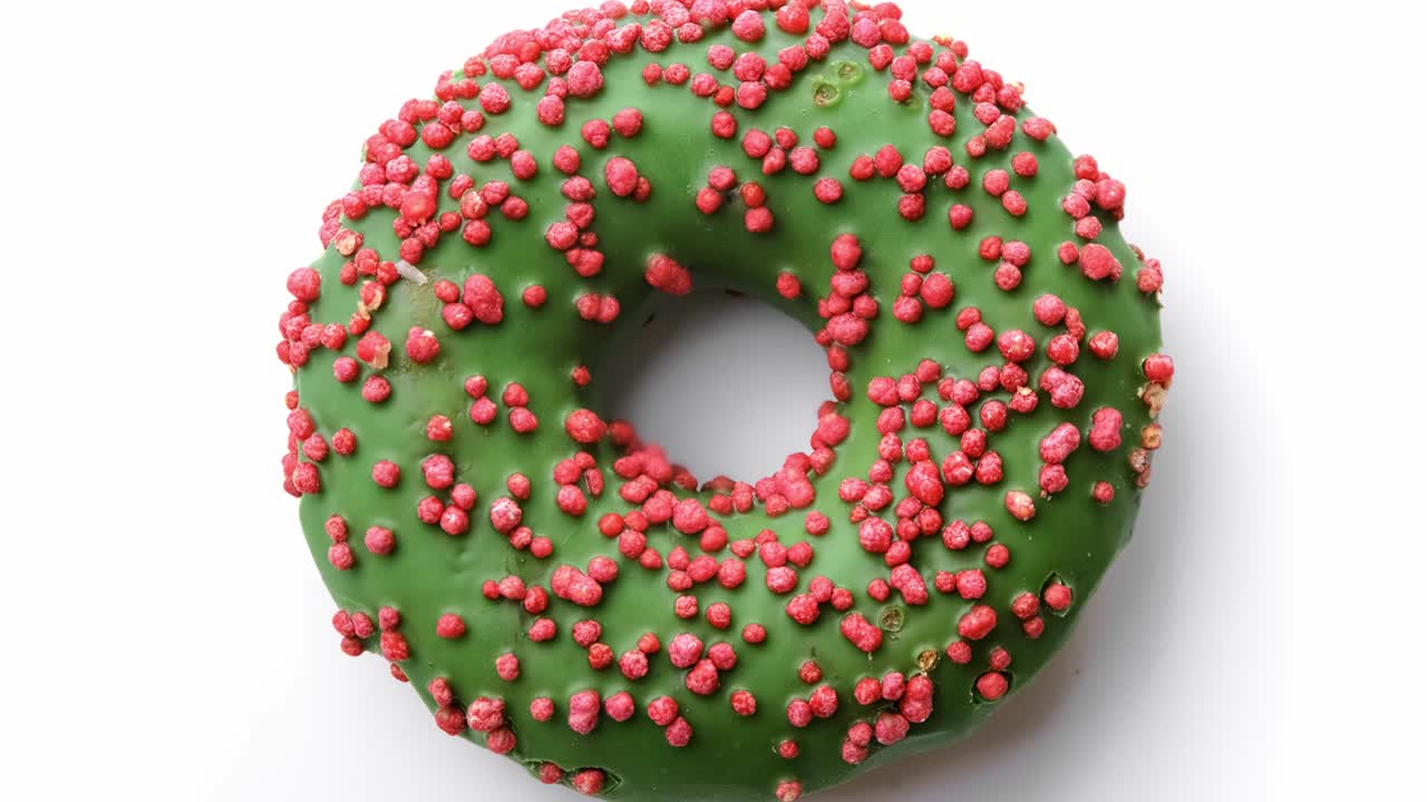 donut con esmaltado verde y pastel rosa en la parte superior girando aislado. filmado con cámara de cine 4k red raven