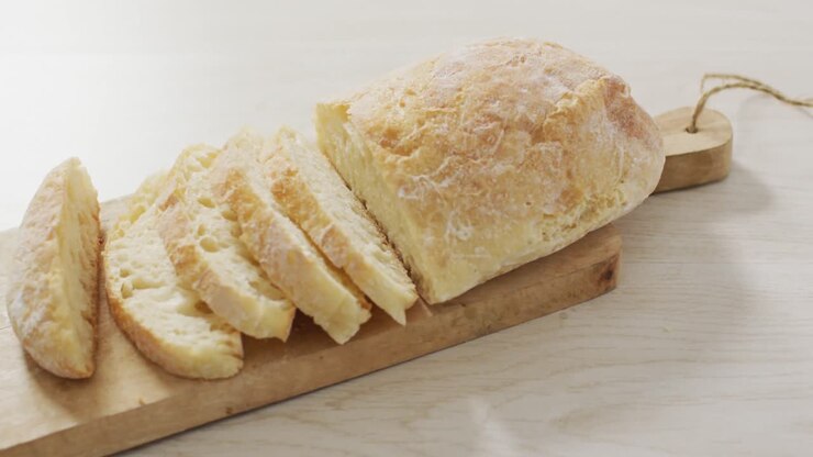 Video of bread on wooden chopping board seeing from above