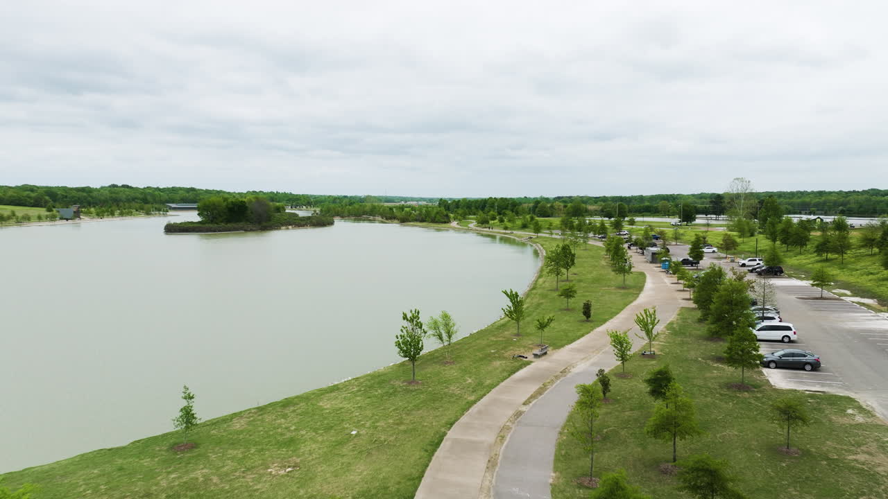 shelby farms park, memphis, con un lago sereno, vegetación y un camino para caminar, vista aérea