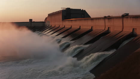 water flowing over a dam at sunset