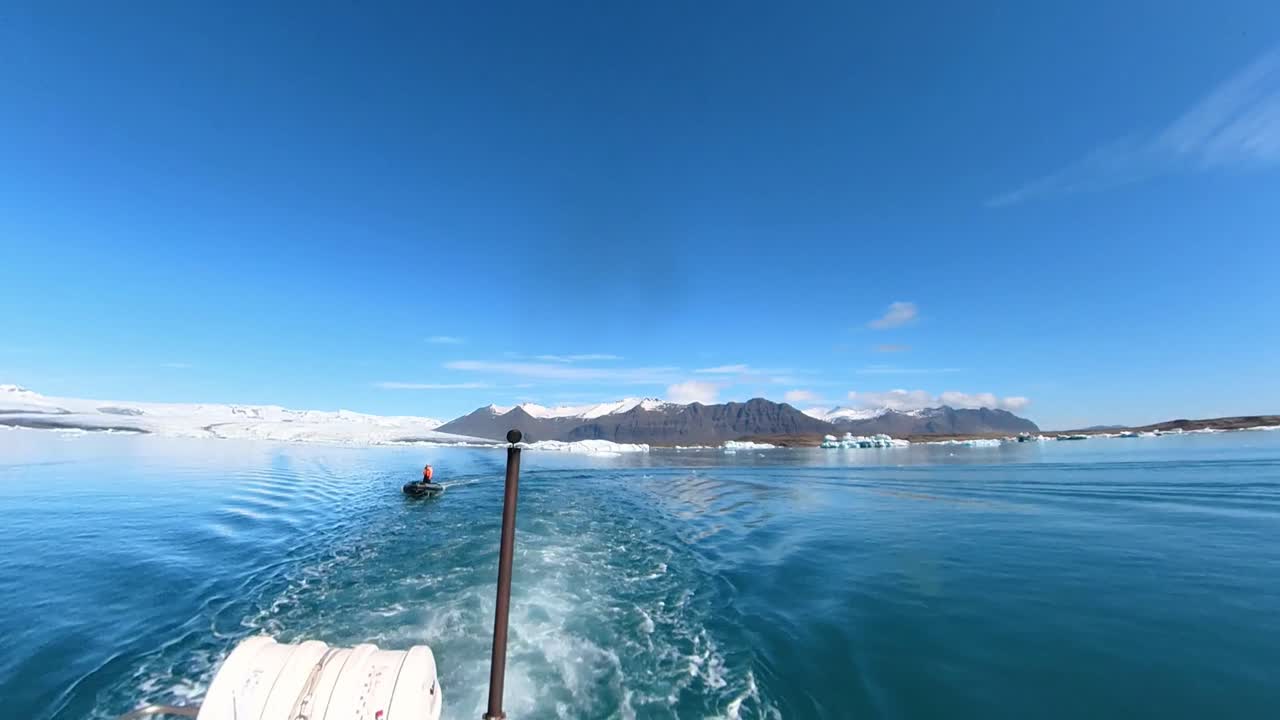 The breathtaking sight of snow-covered mountains in Iceland at jökulsárlón glacier lagoon, perfectly captured with a serene boat gracefully gliding through the scene