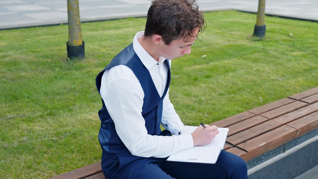 A Businessman Writing In A Journal Outdoors - Close Up