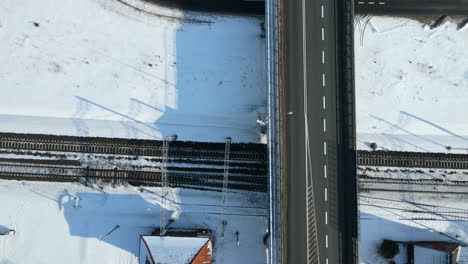 Vista-Superior-Del-Puente-Elevado-Con-Carreteras-Y-Vías-De-Tren-En-Tierras-Nevadas-En-Un-Día-Soleado-De-Invierno-En-Rakowice,-Cracovia,-Polonia