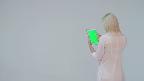 médico presionando la pantalla verde de una computadora tableta