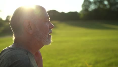 Slow-motion-sunny-scene-of-man-sneezing-showing-aerosol-using-water-hose