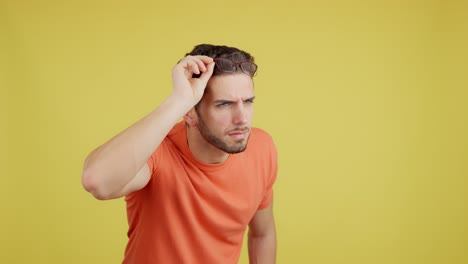 man adjusts and removes glasses to see clearly