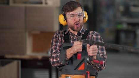 close-up of a young man shooting with a carpenter's clamp