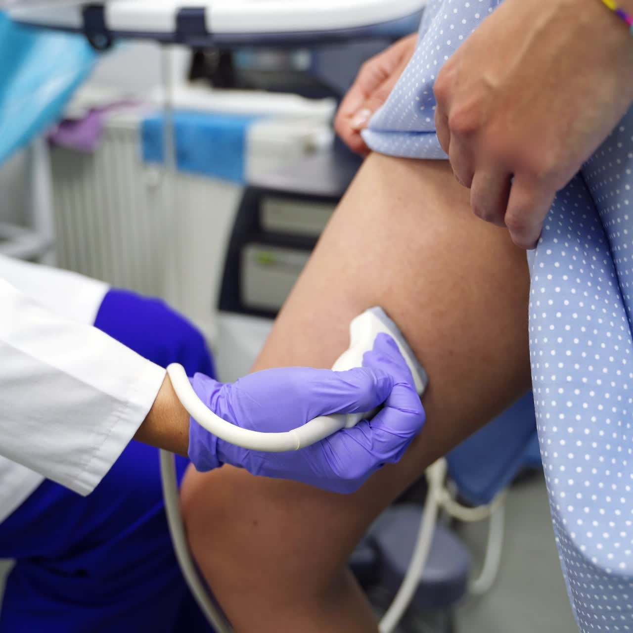 Ultrasonic check up of veins. Female patient stands and doctor moving the sensor by the thigh