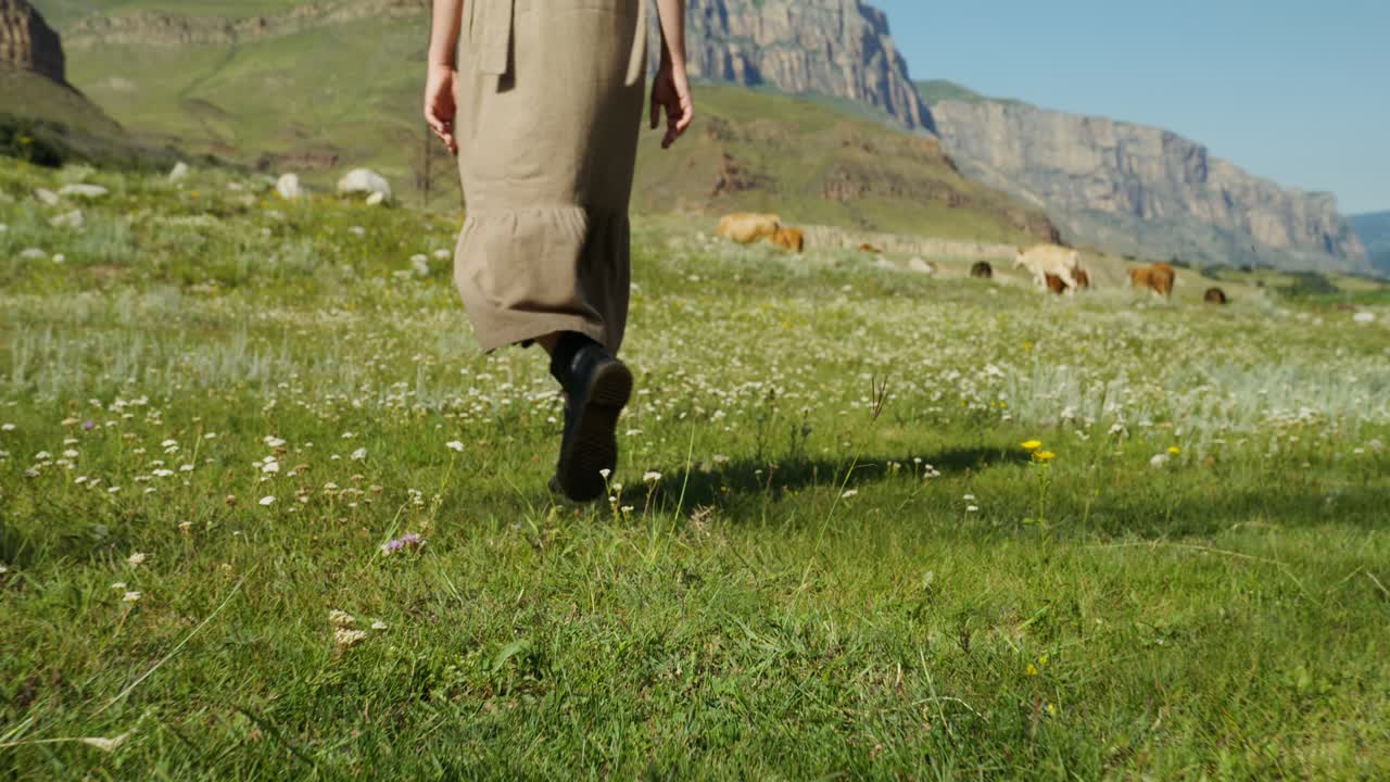 mujer caminando en un prado de montaña