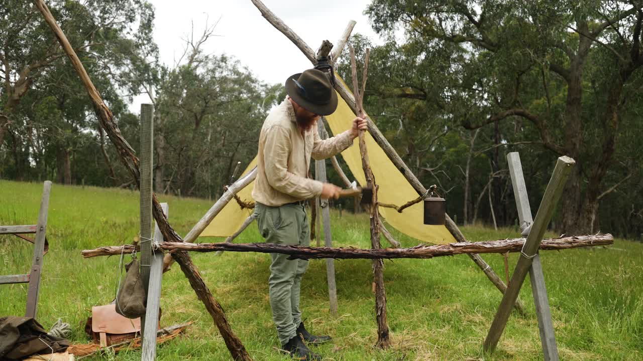 colono australiano del bosque construyendo una cabaña de estilo pionero en el bosque