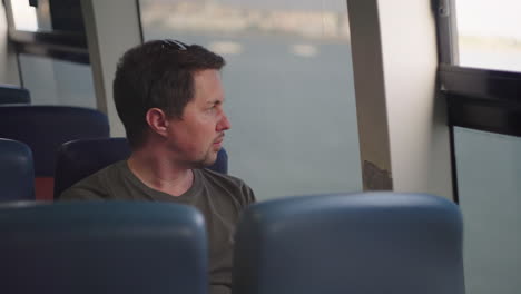 man looking out the window of a ferry