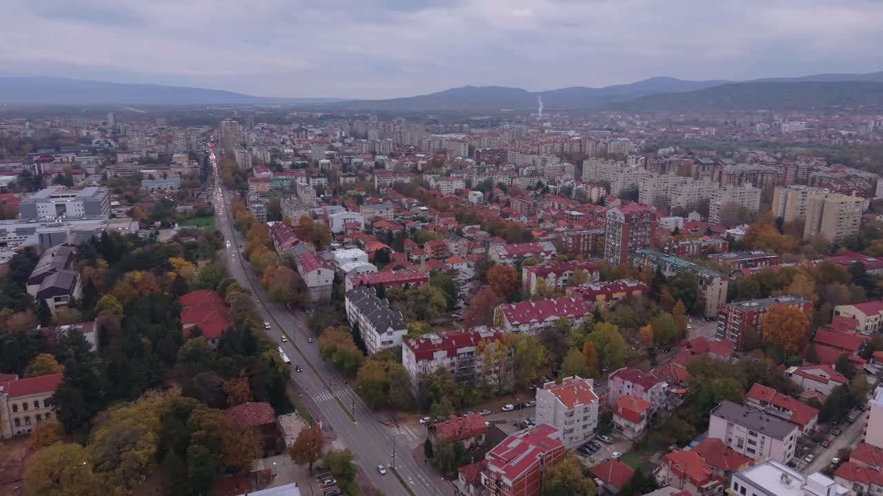 Órbita panorâmica de drone capturando a cidade de Niš de cima, revelando a paisagem urbana, o horizonte e o terreno circundante em um movimento cinematográfico suave