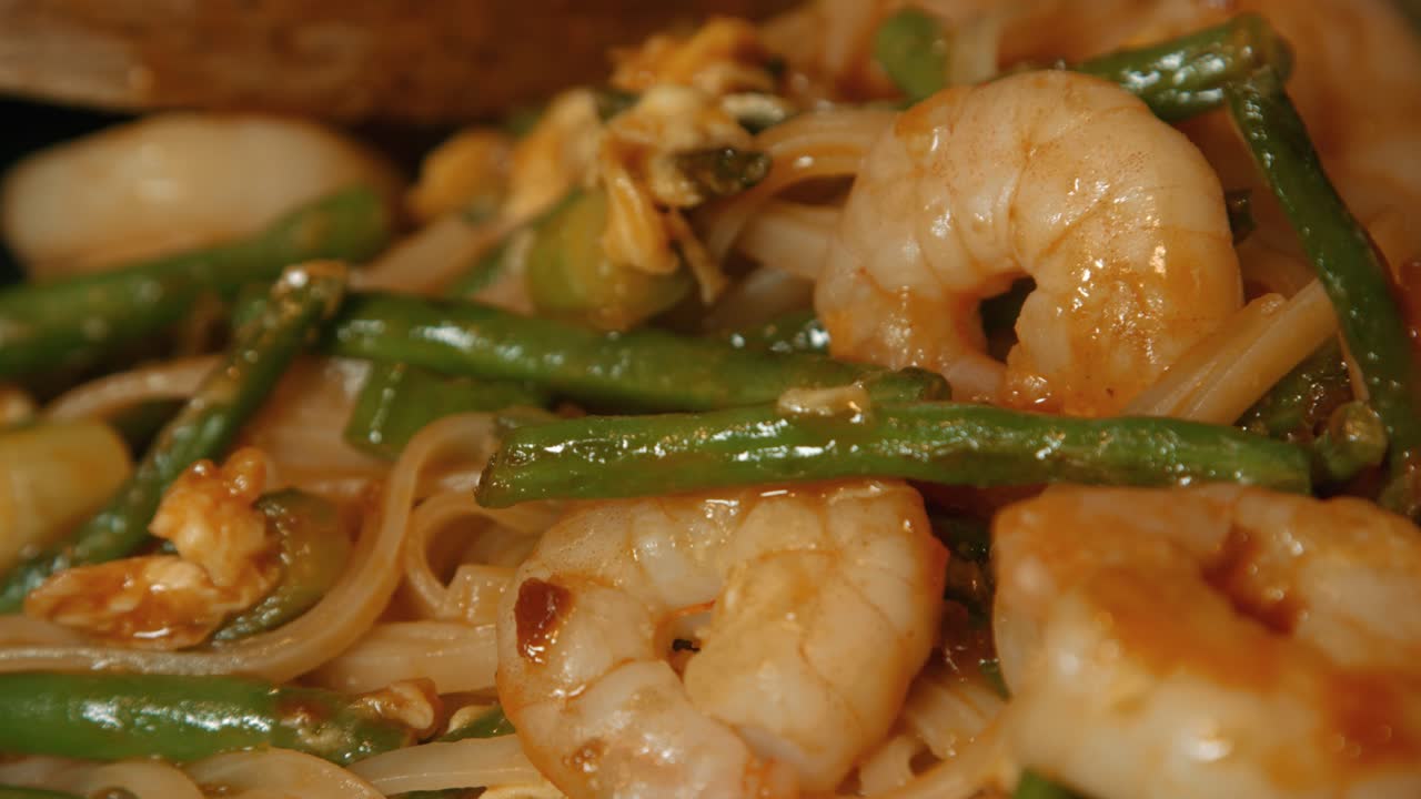 cerca de pad thai con camarones rey, fideos y frijoles