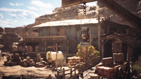 a rustic lantern hanging in a dusty old settlement during the day