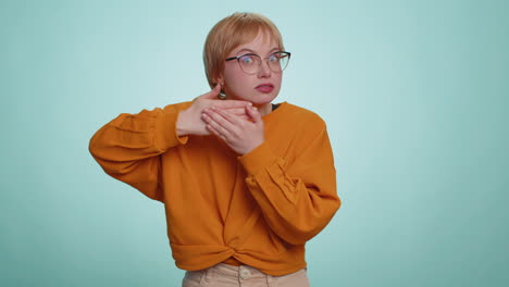 young woman with short blonde hair and glasses looking surprised