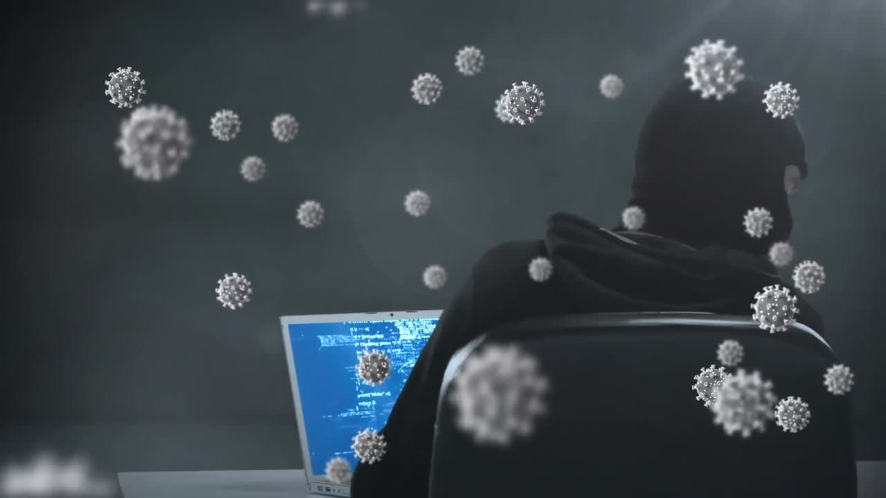 노트북을 사용하여 발라클라바를 입은 남성에 대한 거대한 코로나19 세포의 애니메이션