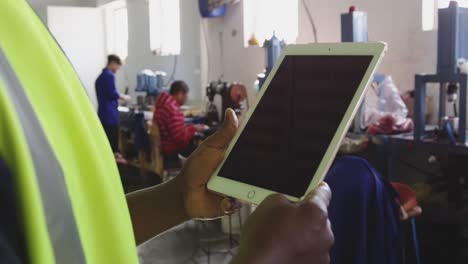 close up view of worker using tablet computer in factory