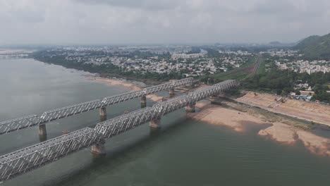 aerial view of a railway bridge over a river in a city
