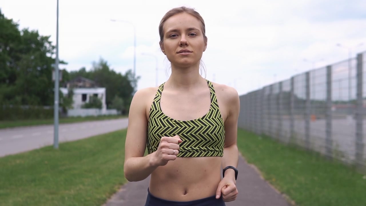 Focused Young Woman Running Outdoors in Slow Motion