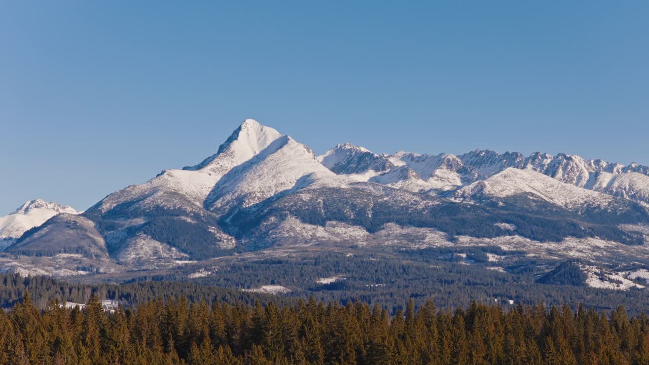 Vista ravvicinata dell'iconica vetta del Kriváň negli Alti Tatra, Slovacchia. Pendii montuosi innevati e creste alpine frastagliate sotto un cielo azzurro limpido, paesaggio invernale tranquillo con forte simbolismo nazionale