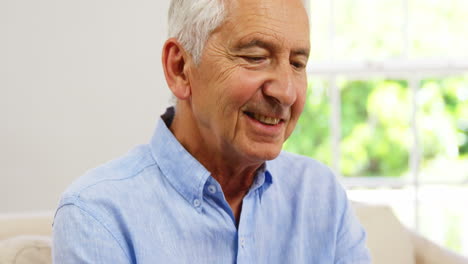 Mature-man-sitting-and-using-a-smartphone