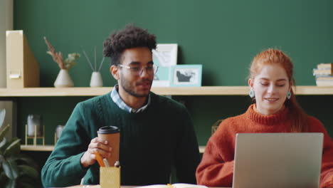 two students collaborating on a laptop