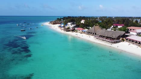 Eine-Drohnenaufnahme-Von-Zwei-Booten,-Die-An-Einem-Schönen-Und-Sonnigen-Tag-Am-Nungwi-Strand-Auf-Der-Tropischen-Insel-Sansibar-In-Tansania-In-Afrika-Vorbeifahren