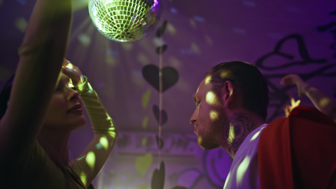 Energetic teenagers moving body at dance floor under disco ball light closeup
