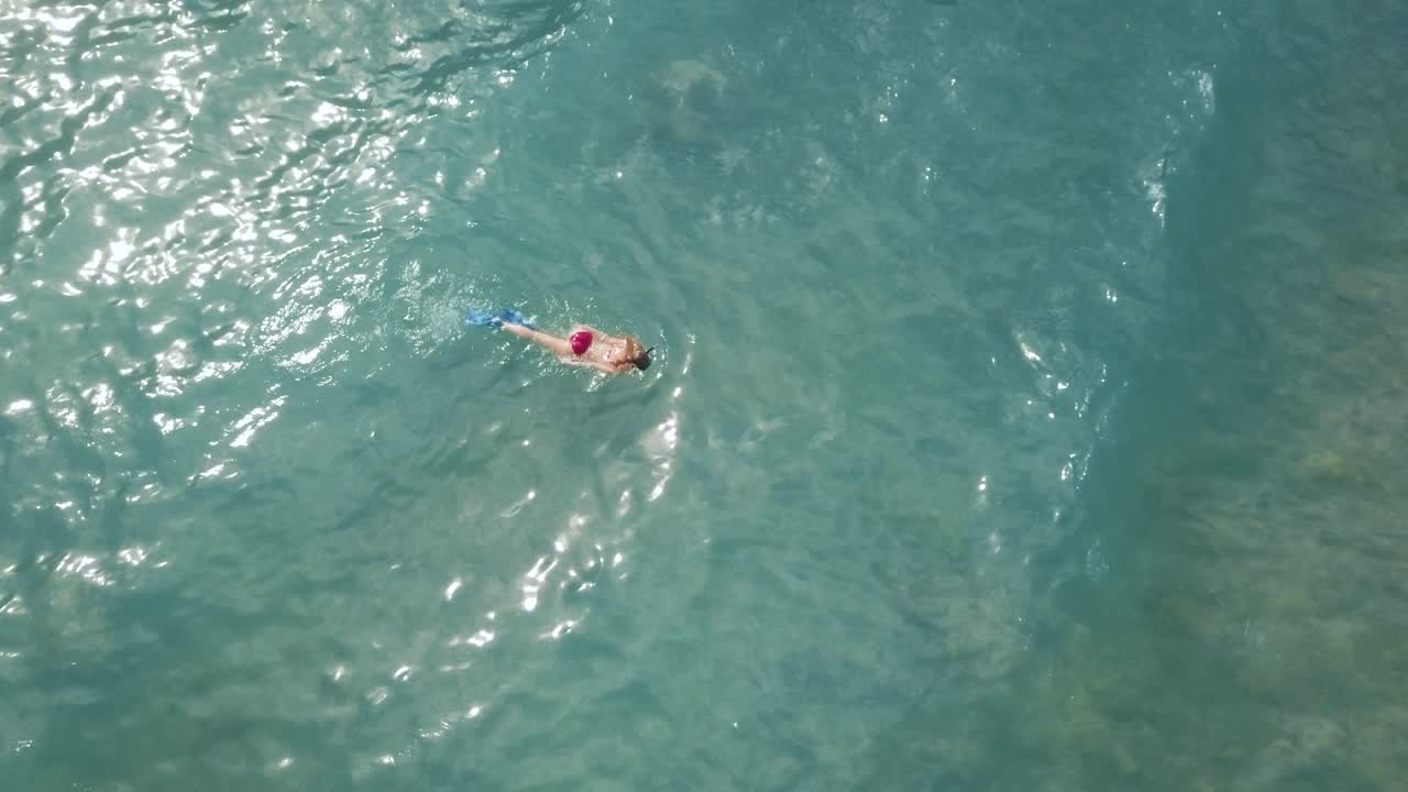 girl snorkeling over a nice reef in a beautiful blue ocean on a sunny day in Hawaii