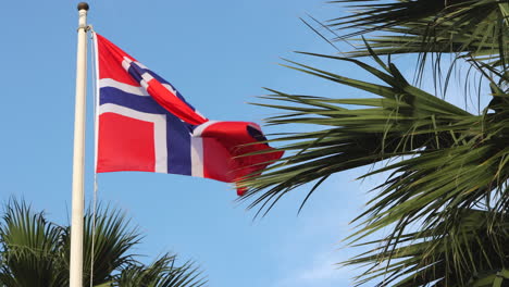 la bandera noruega sopla lentamente con la brisa contra el azul