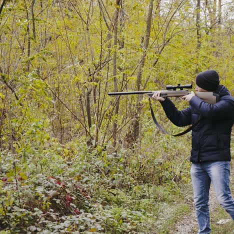 hombre apuntando con un rifle de caza