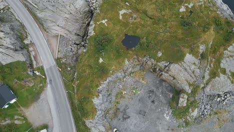 panorámica de la vista aérea sobre el coche aparcado que revela el paisaje circundante con el amplio océano en lofoten, al norte de noruega