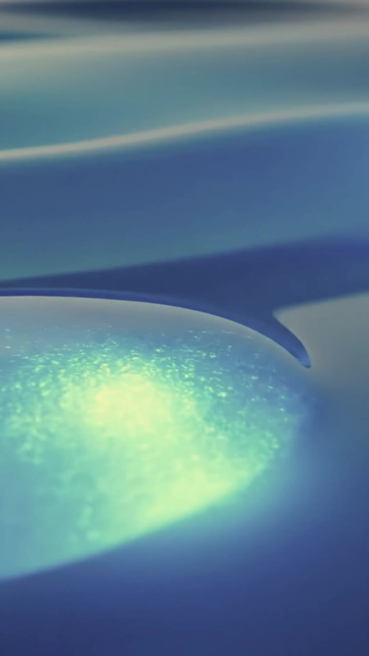 Sfera Luminosa Eterea in Movimento su Superficie Liquida Blu Ondulata