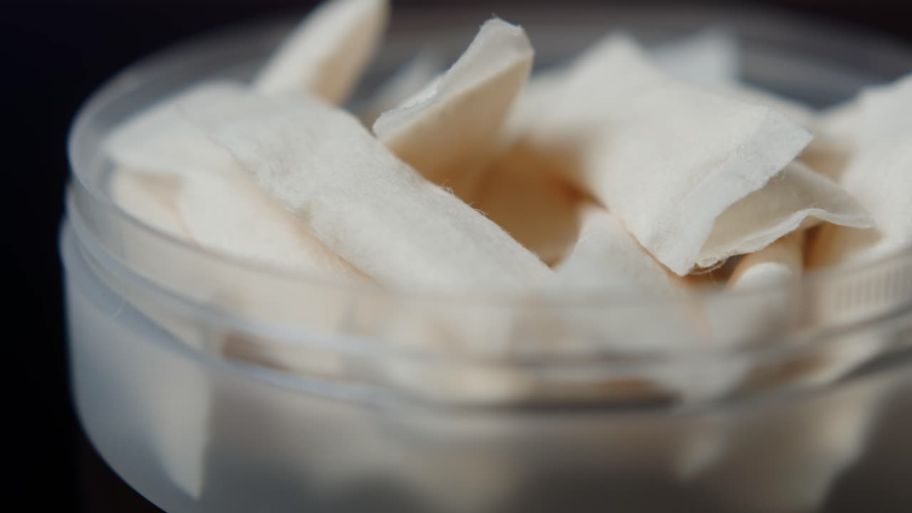 Snus nicotine tobacco close up, pack of tobacco for gum. unhealthy addiction. Man opening box with snus and taking one.