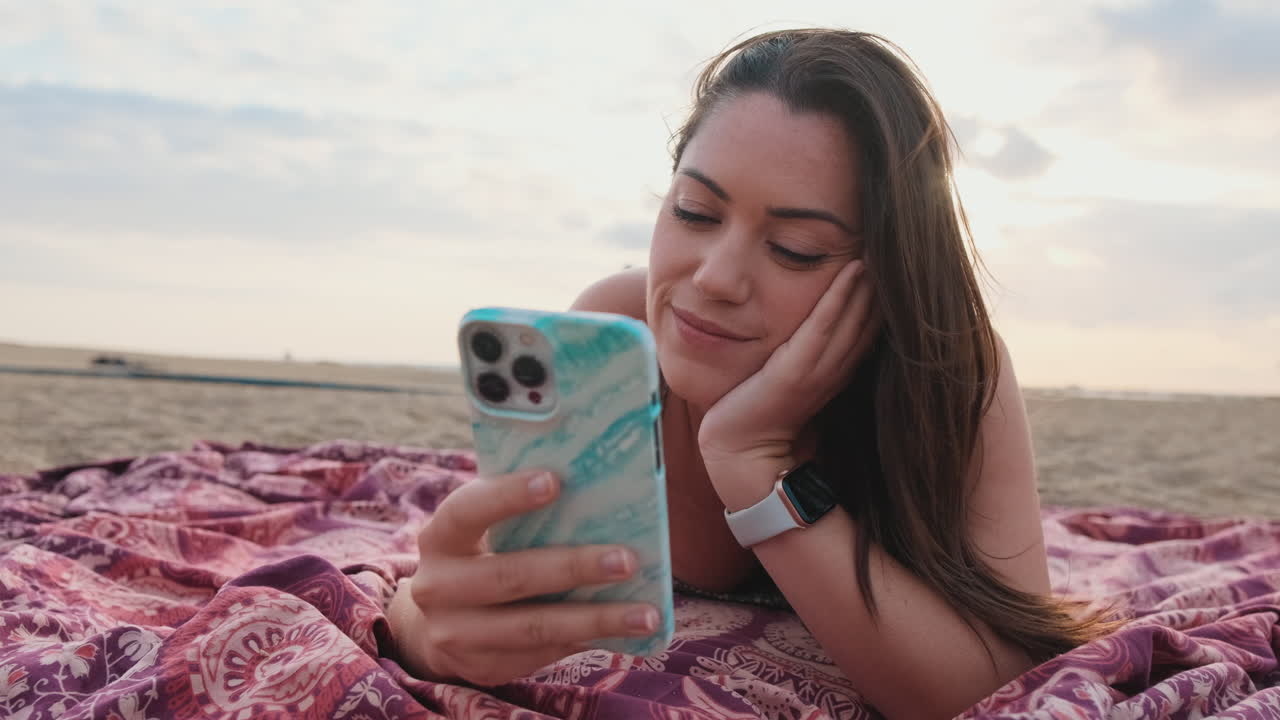 Woman relaxing on the beach with a smartphone