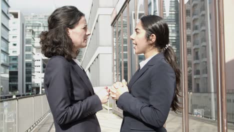 businesswomen standing and talking on street