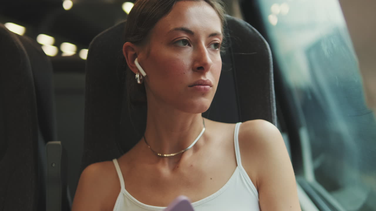 Donna seduta in treno con gli auricolari
